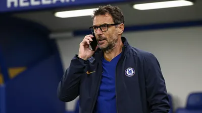 A 35-year-old Chelsea FC assistant coach, with a rugged build and receding dark hair, stands in the tunnel at Stamford...